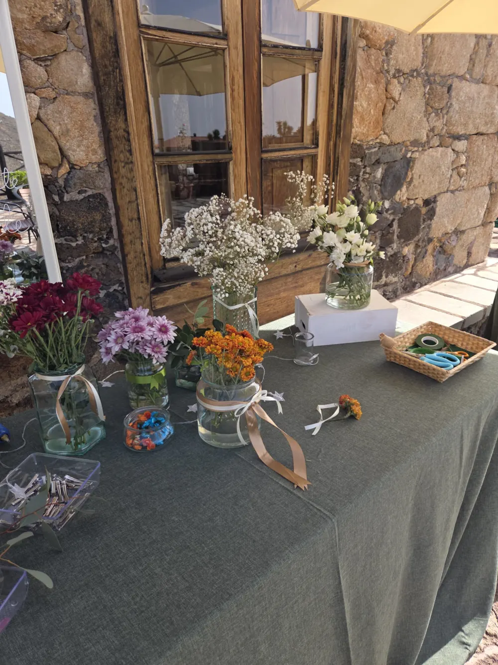 Mesa del flower bar con flores por colores y cesta de herramientas