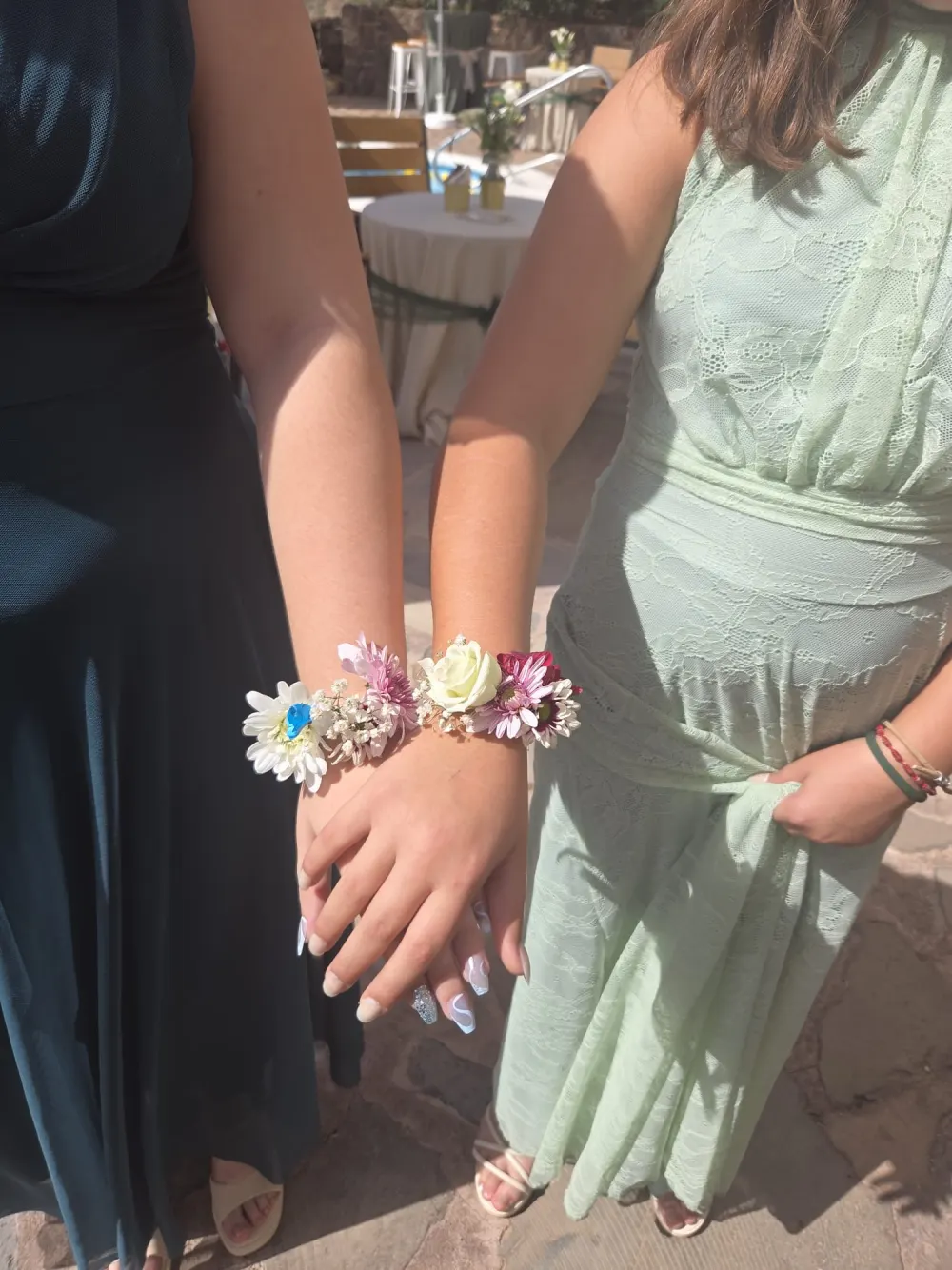 Dos invitadas con pulseras de flores en la muñeca
